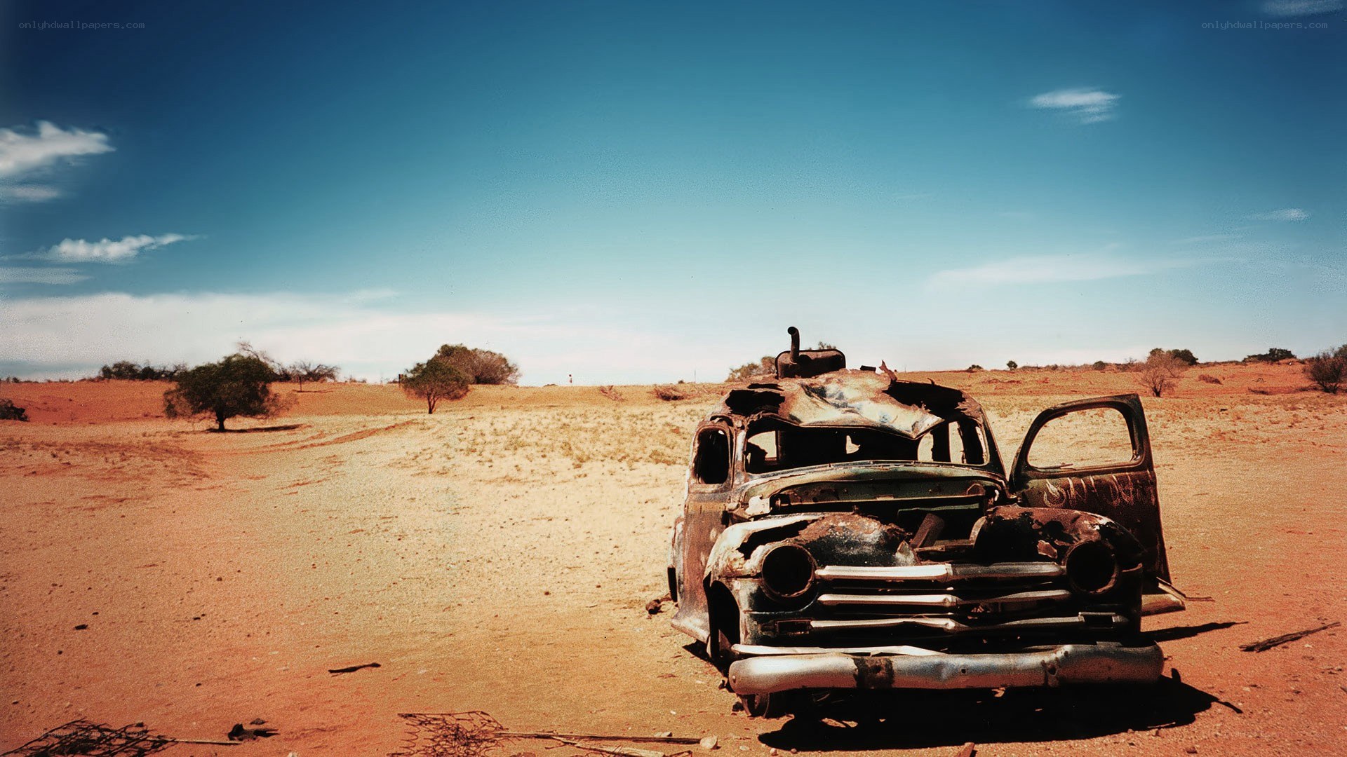 Rusty car in desert landscape