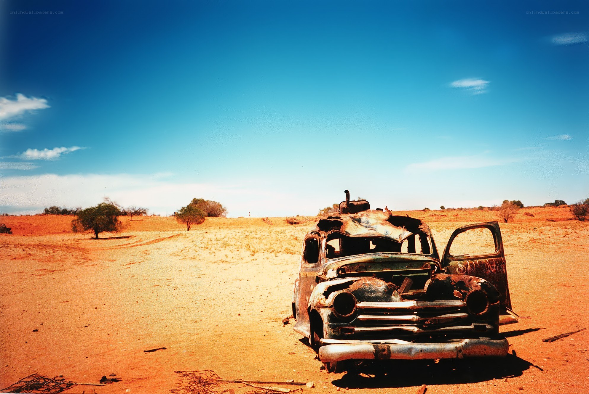 Rusty car in desert landscape