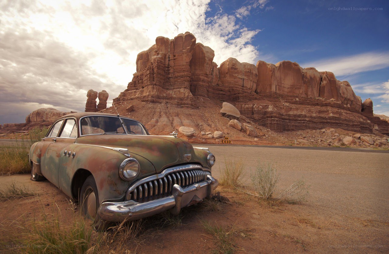 Rusty car in desert landscape