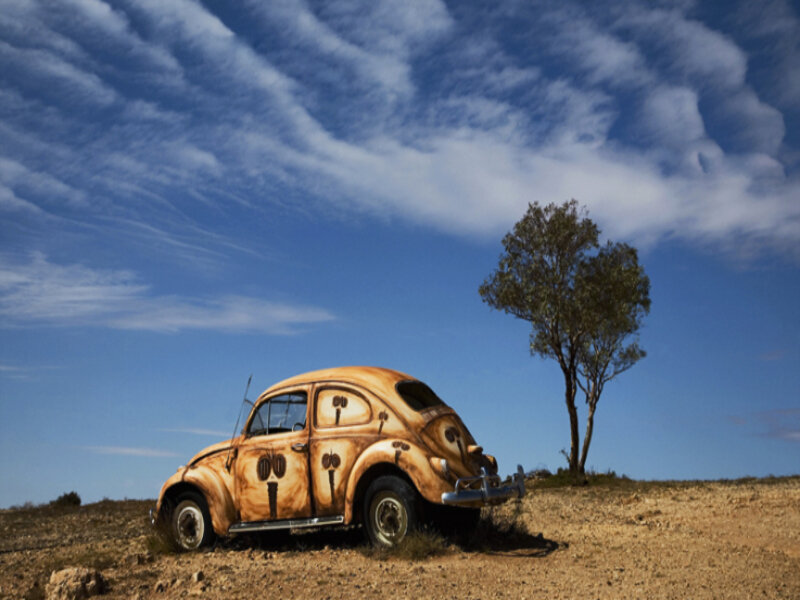Rusty car in desert landscape