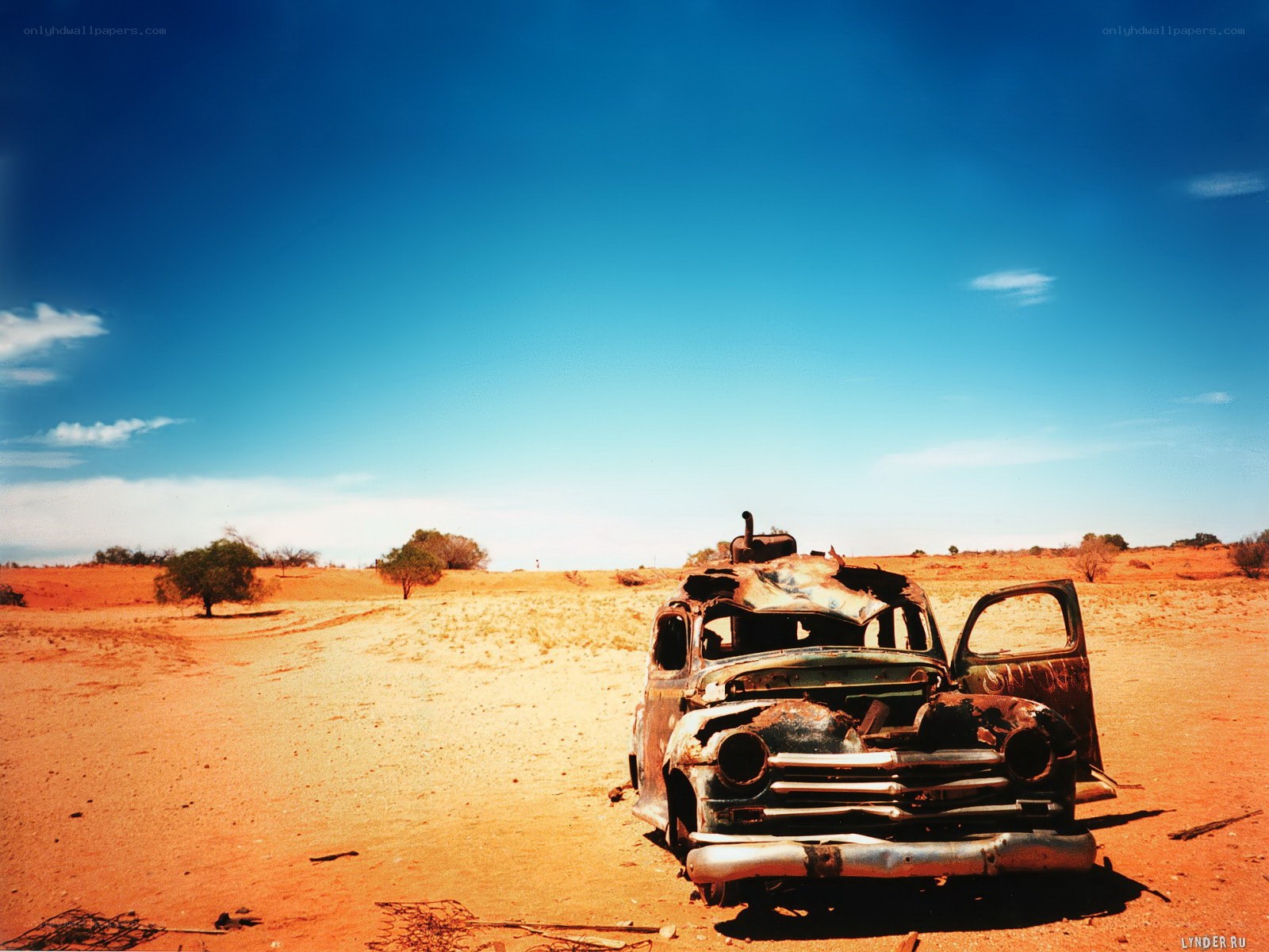 Rusty car in desert landscape