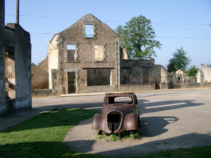 Rusty car in front of ruins