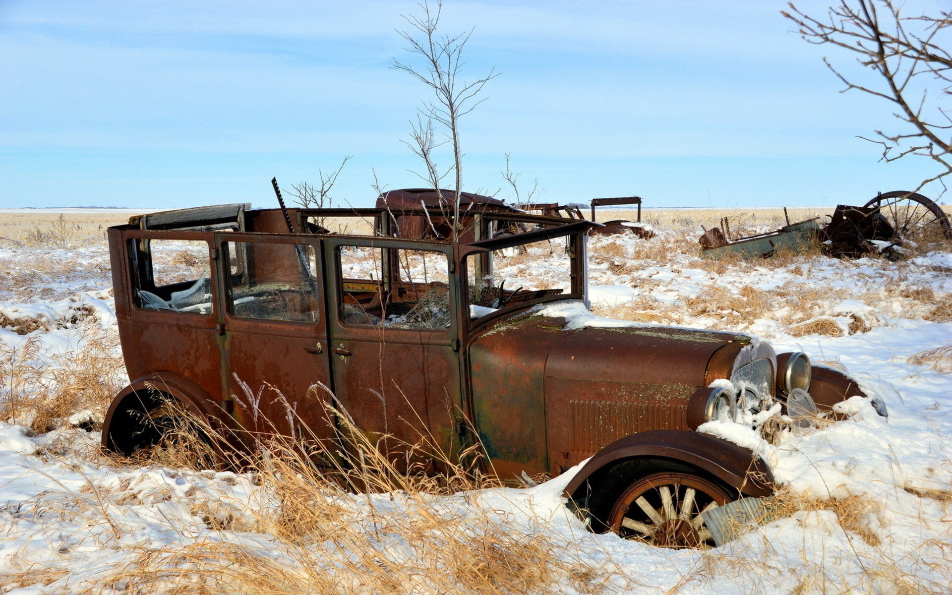 Rusty car in snowy field