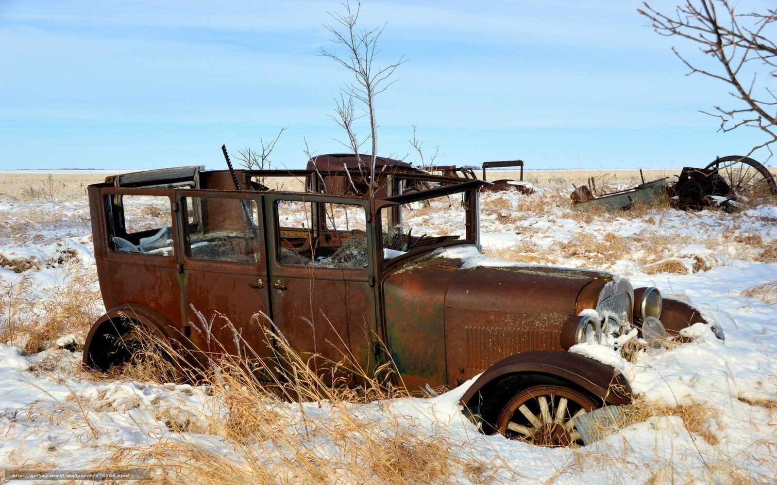 Rusty car in snowy field
