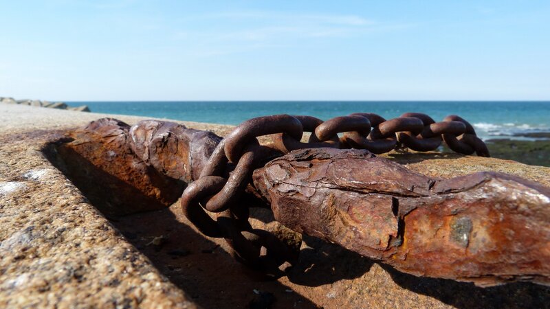 Rusty chain on a seaside wall