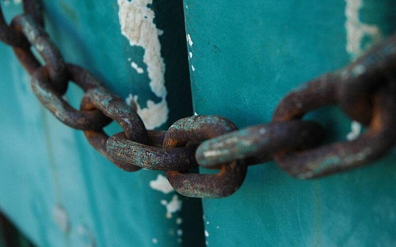 Rusty Chain on Metal Surface — Teal
