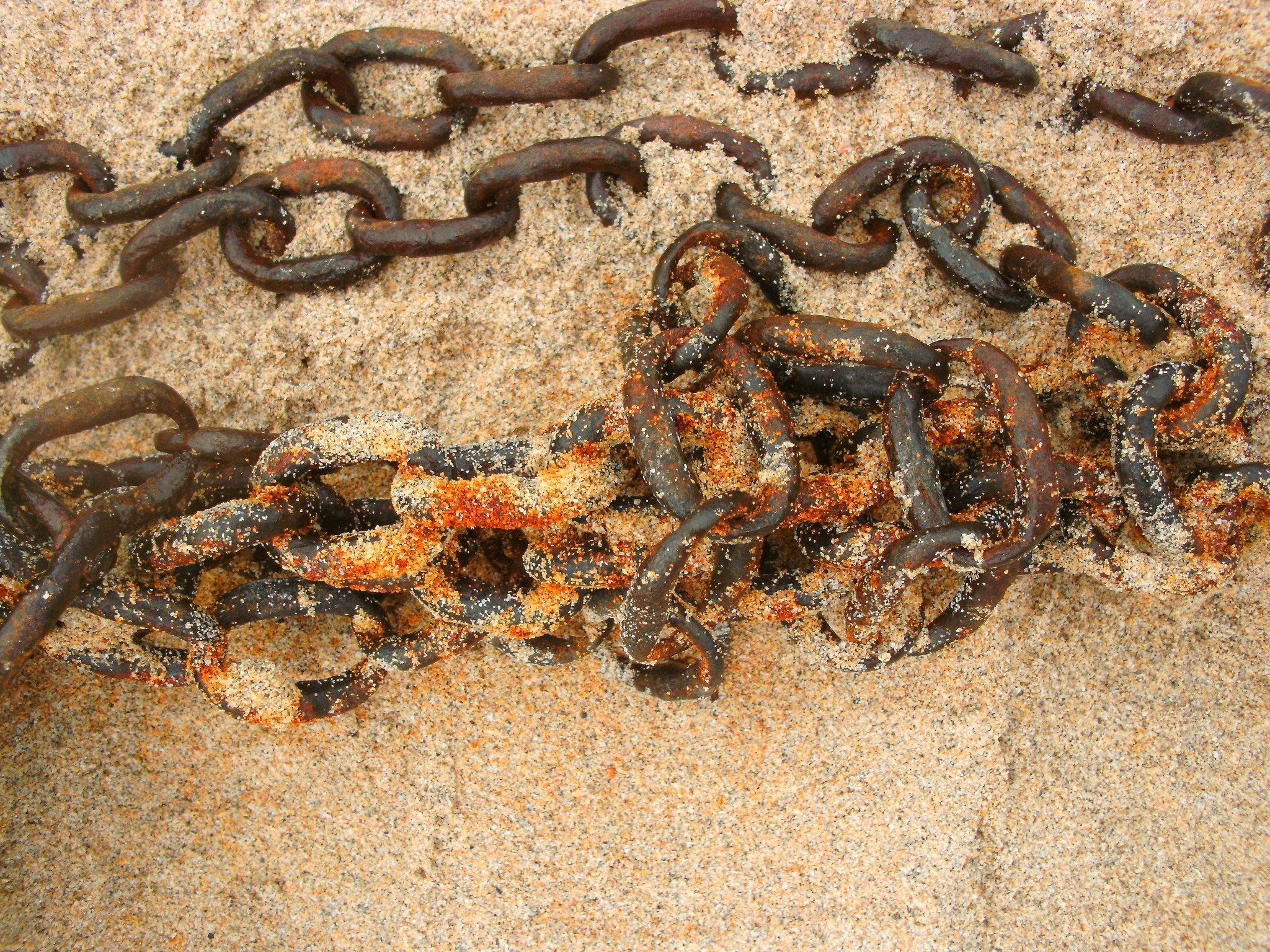 Rusty chain on sandy beach