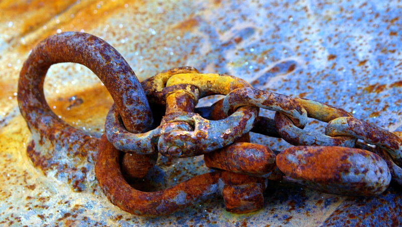 Rusty chain on weathered metal