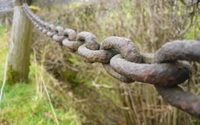rusty chain on wooden post