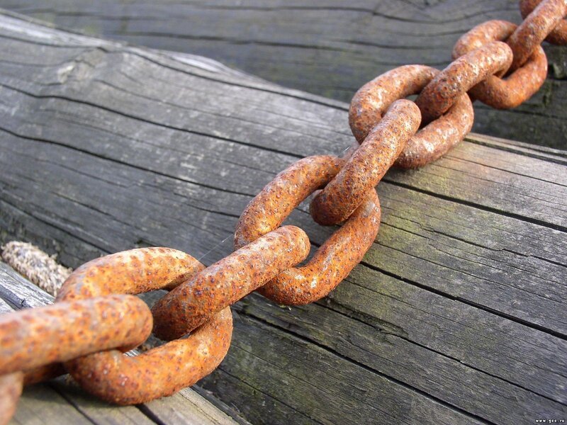 Rusty chain on wooden surface