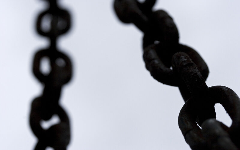 Rusty chains against sky