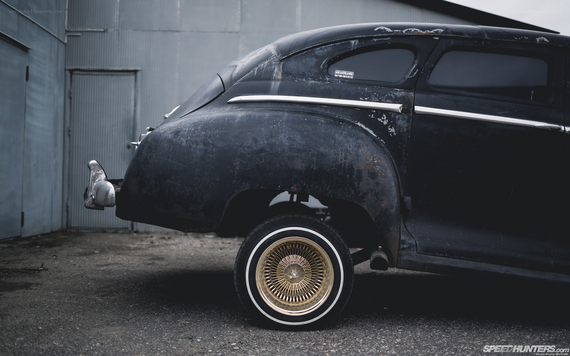 Rusty classic car with gold wheels