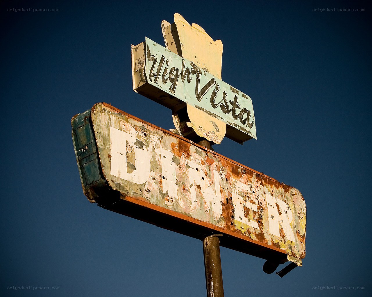 Rusty diner sign against blue sky