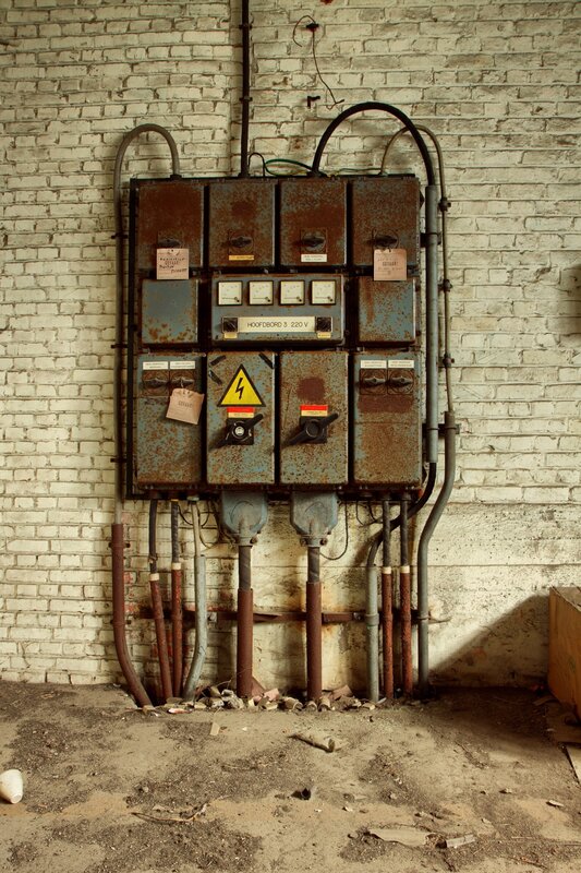 Rusty electrical panel on brick wall