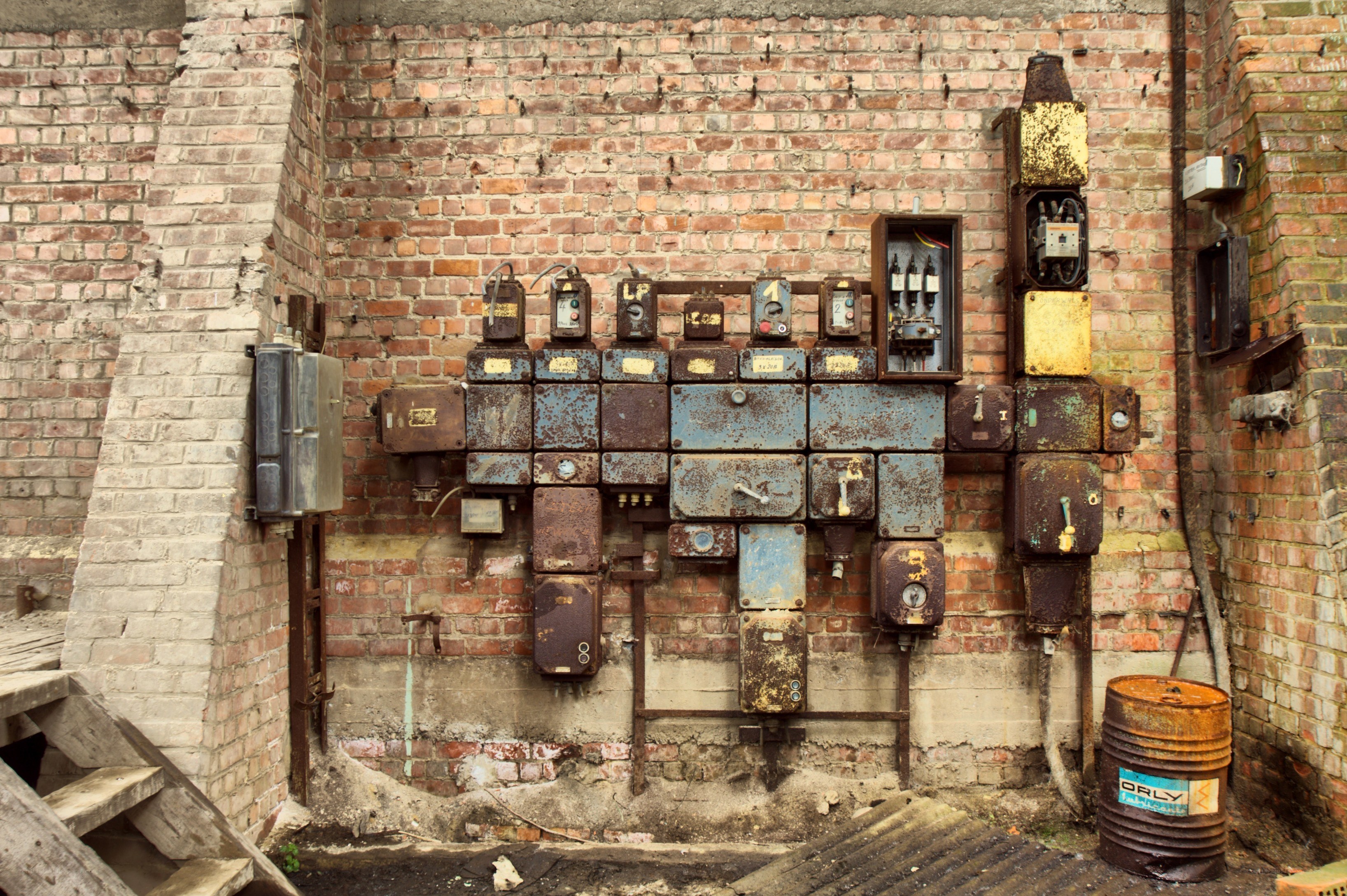 Rusty electrical panels on brick wall