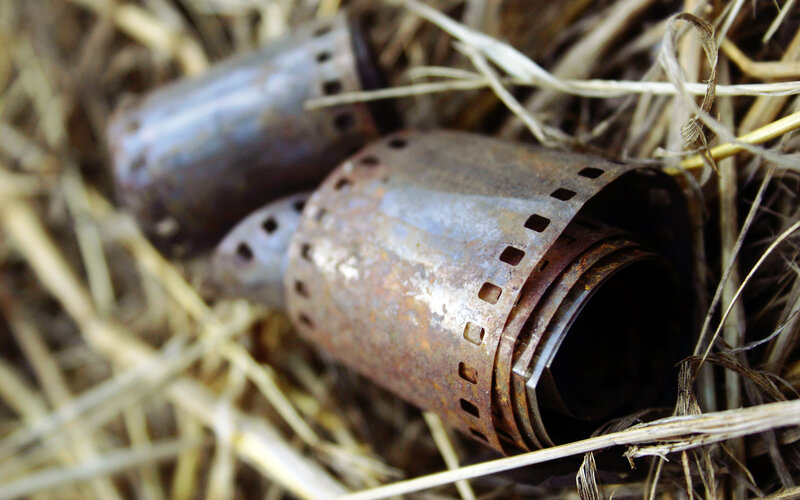 Rusty film canisters in straw
