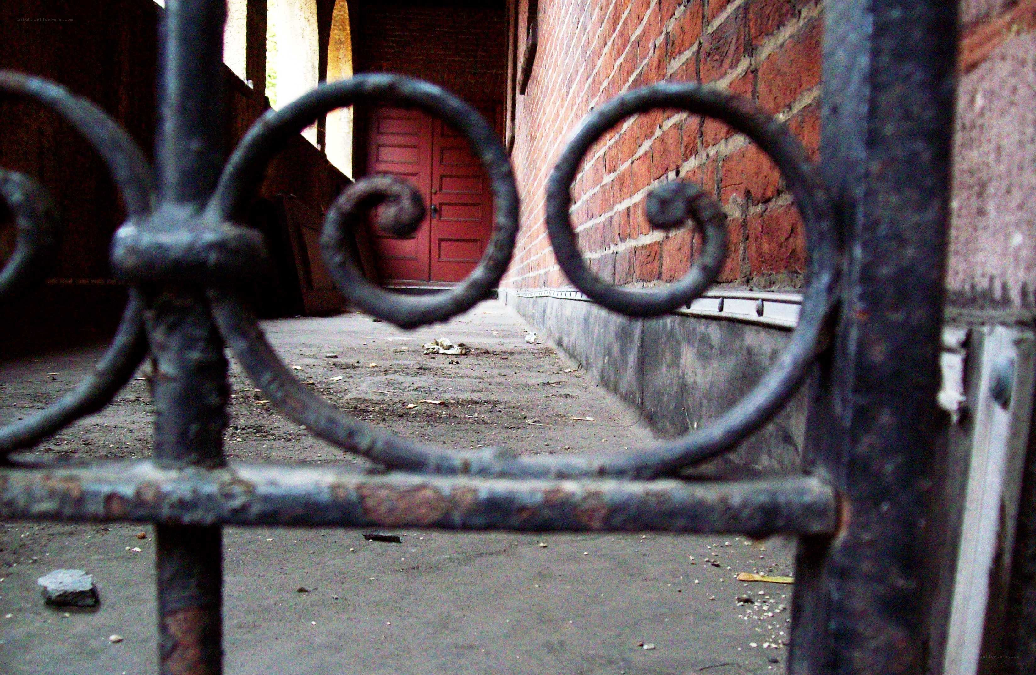 Rusty gate and brick alley