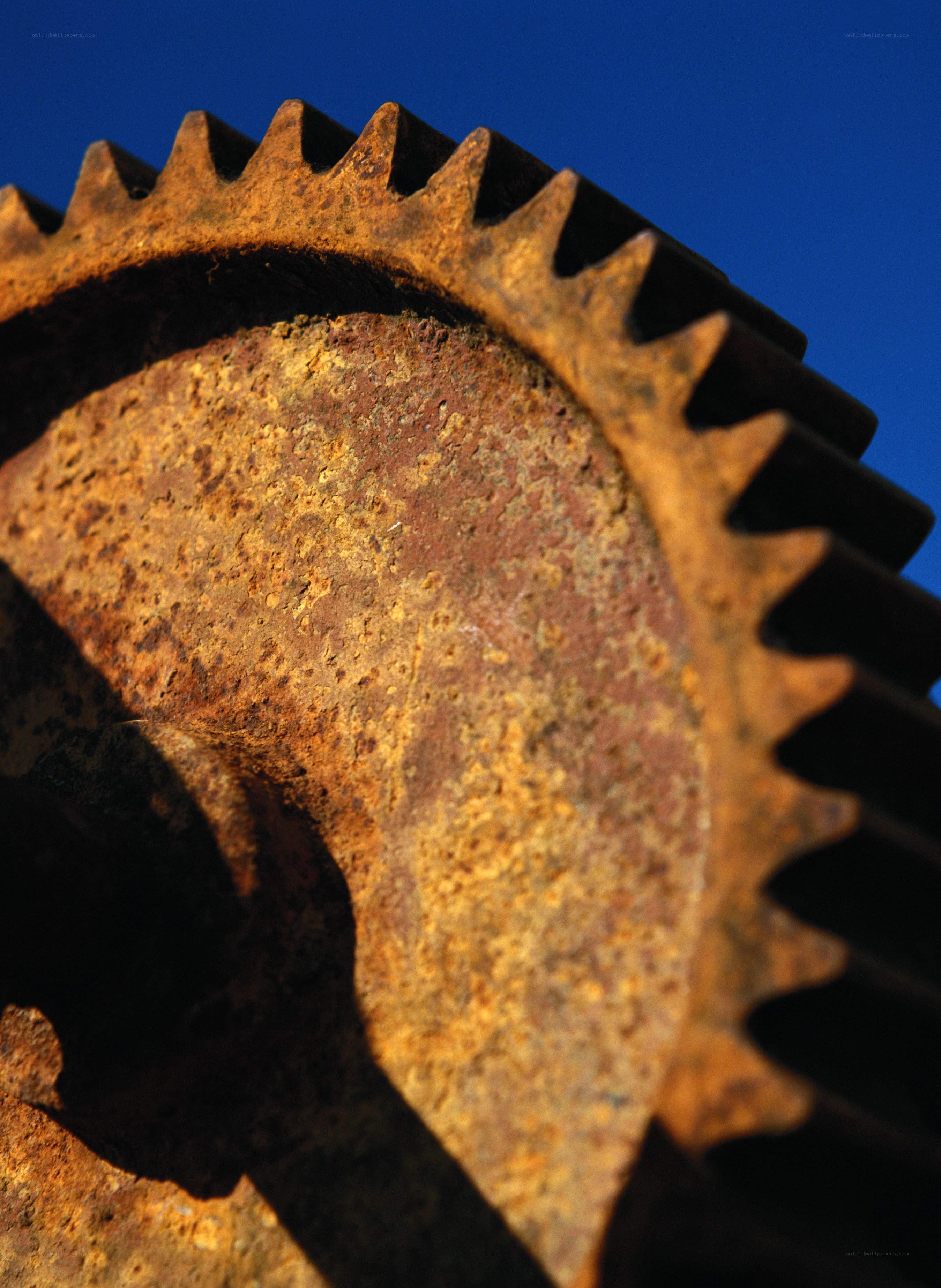 Rusty gear against blue sky