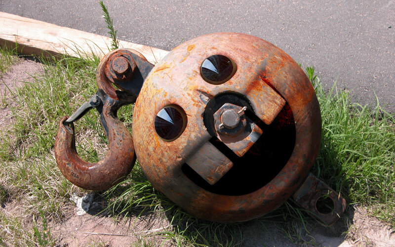 Rusty hook and ball in grass