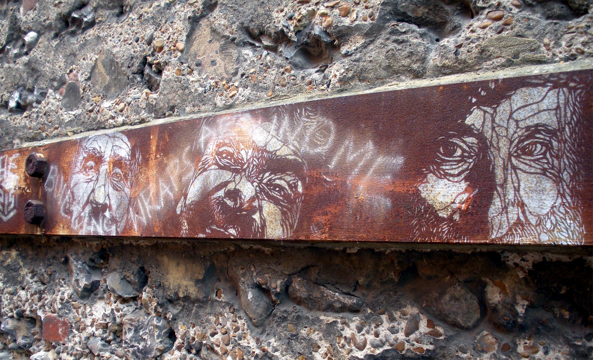 rusty metal art on stone wall