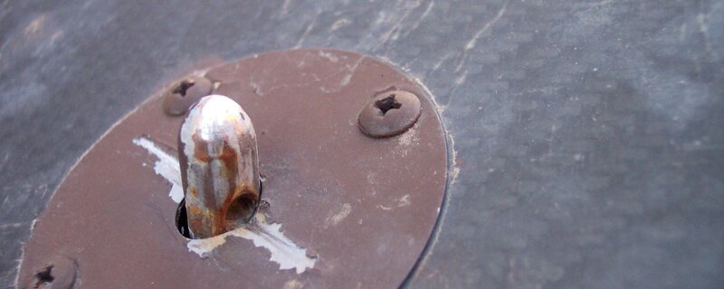 Rusty metal fixture on dark surface