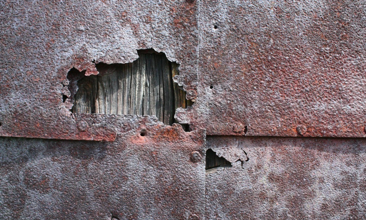 Rusty metal wall with holes