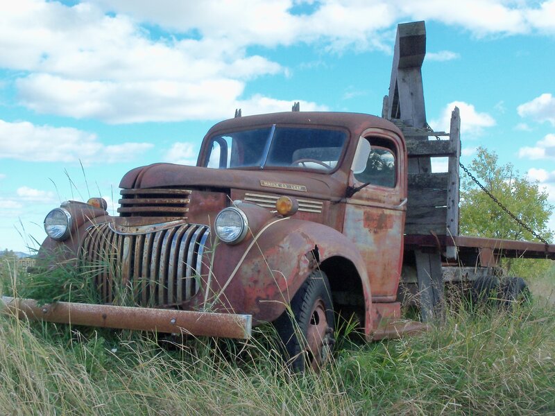 Rusty old tow truck in field