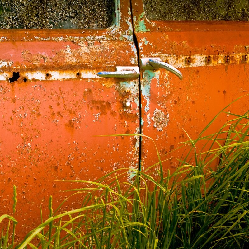 Rusty orange door with grass