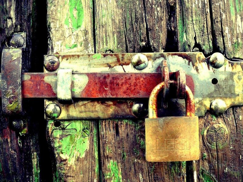 rusty padlock on wooden door