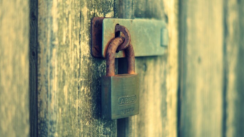 rusty padlock on wooden door
