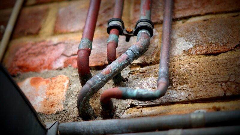 Rusty pipes on brick wall