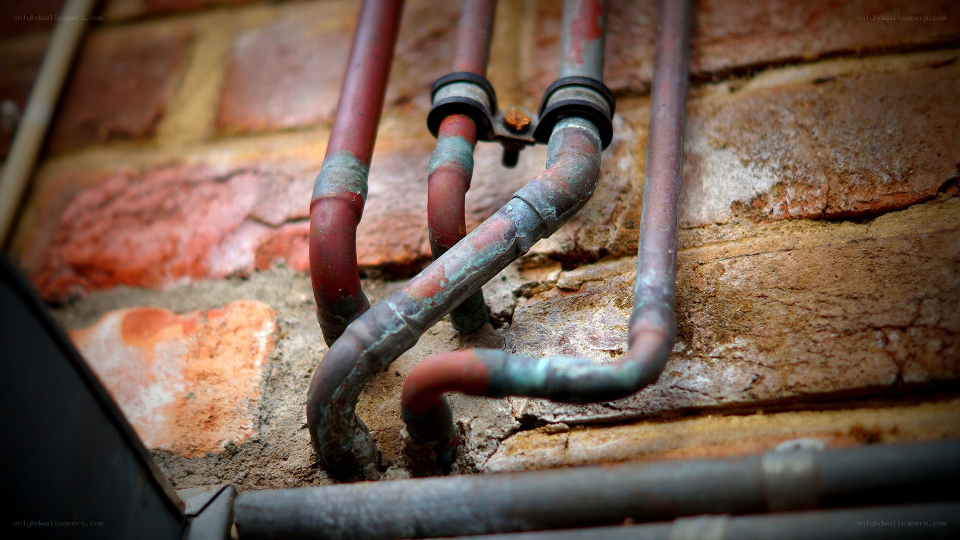 Rusty pipes on brick wall