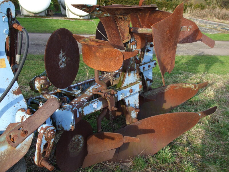 Rusty plow on grass