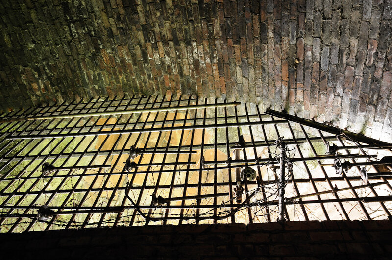 Rusty prison bars in brick tunnel
