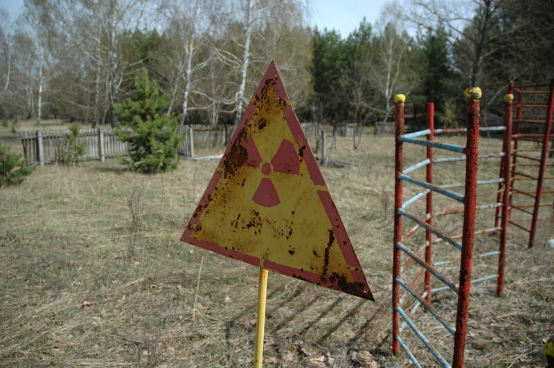 Rusty radiation sign in field