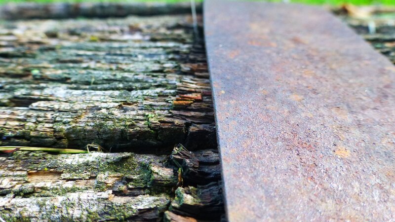 Rusty rail on decaying wooden planks