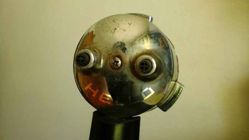Rusty robot head with 'HELLO' text