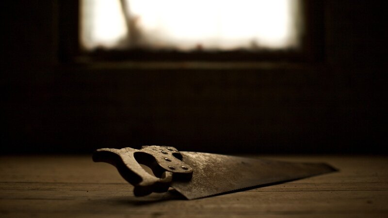 rusty saw on wooden surface
