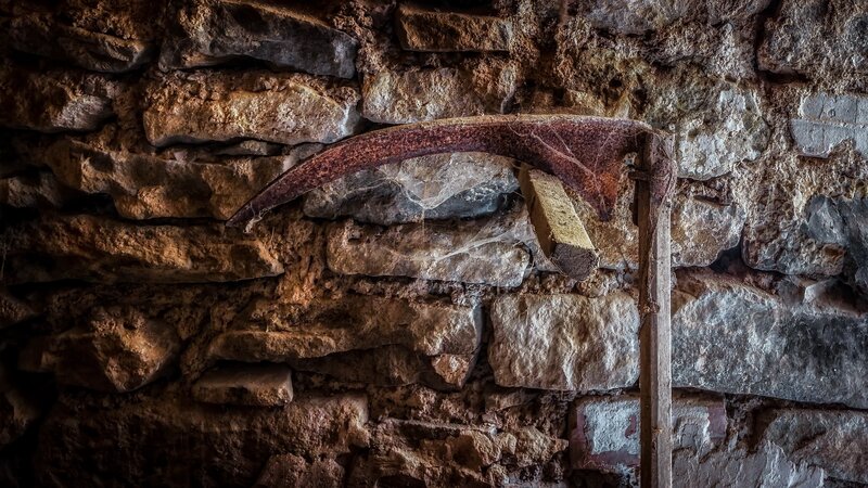 Rusty Scythe on Stone Wall