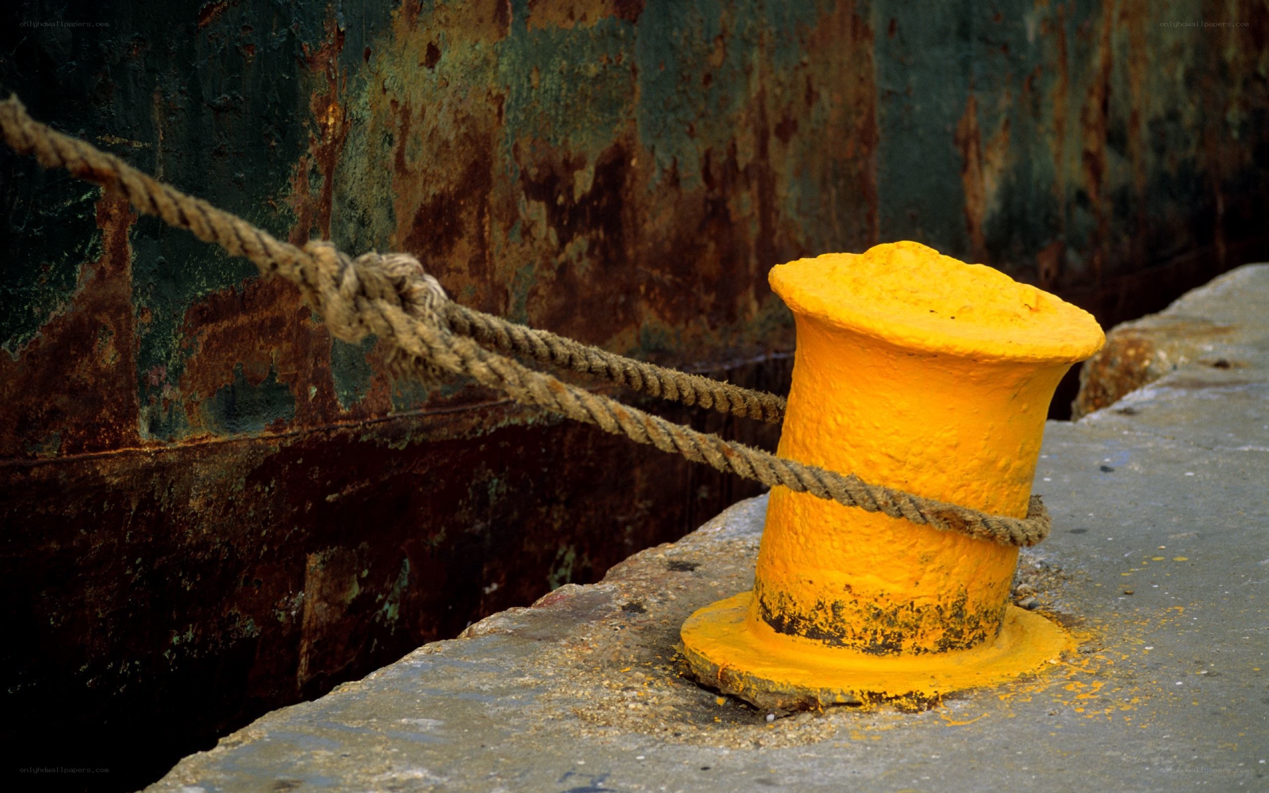 Rusty ship and yellow bollard