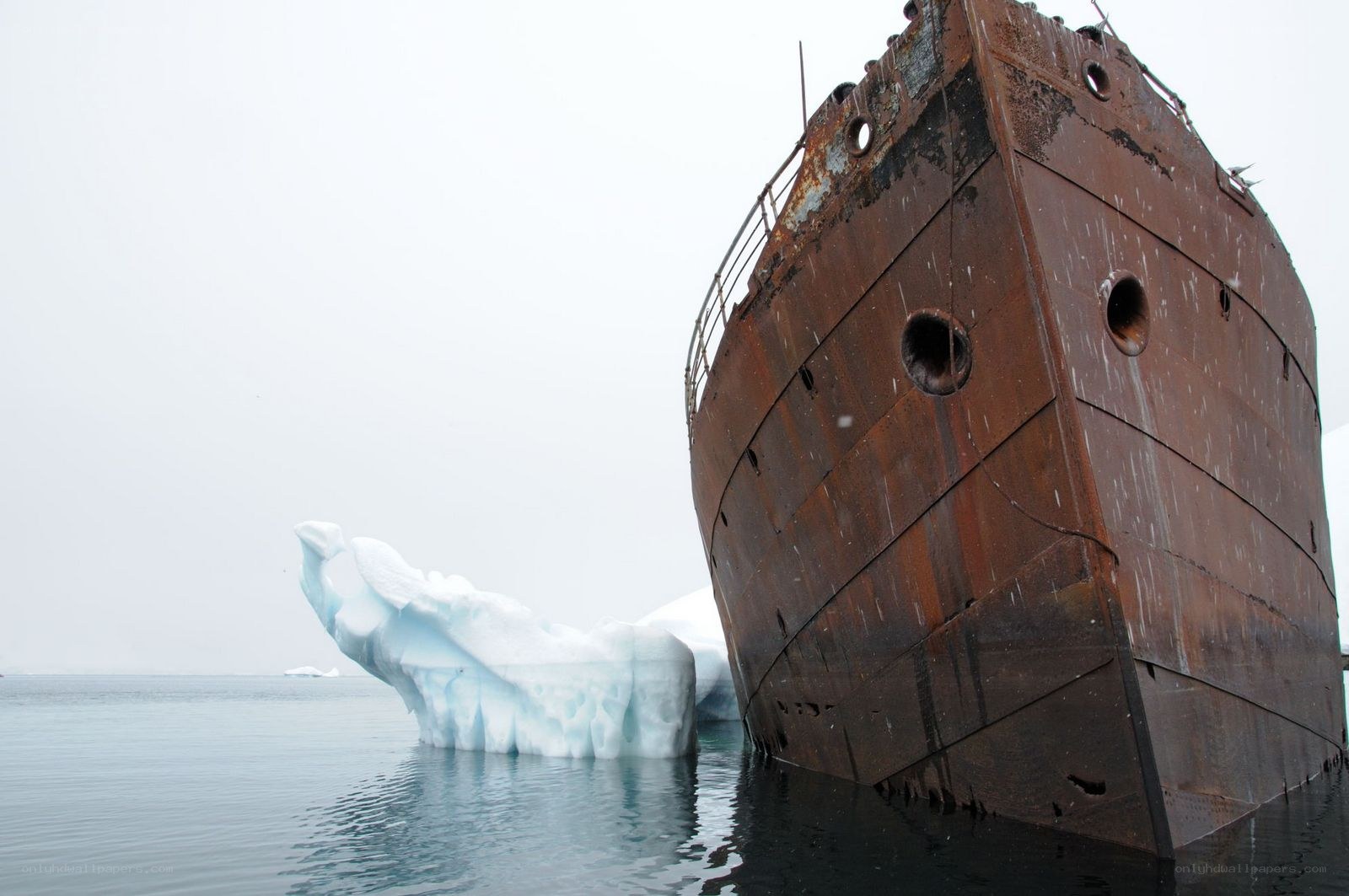 Rusty shipwreck near iceberg