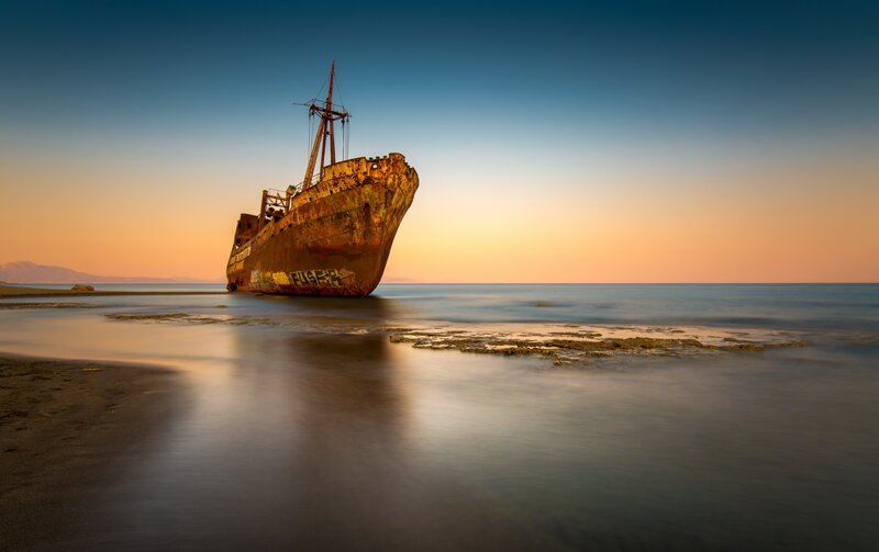 Rusty Shipwreck on Beach — Blue, Serene, Sunset