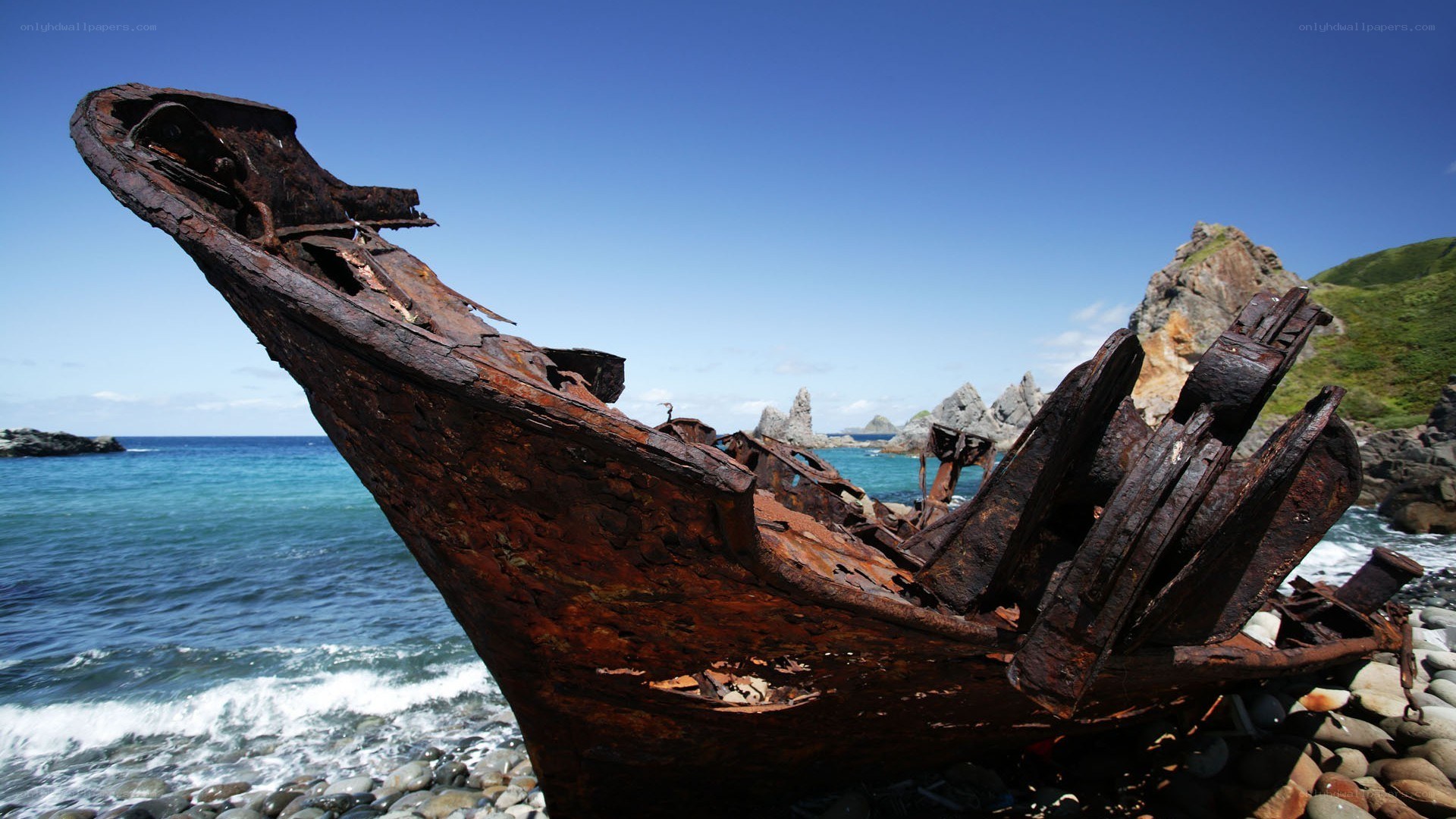 Rusty shipwreck on rocky shore