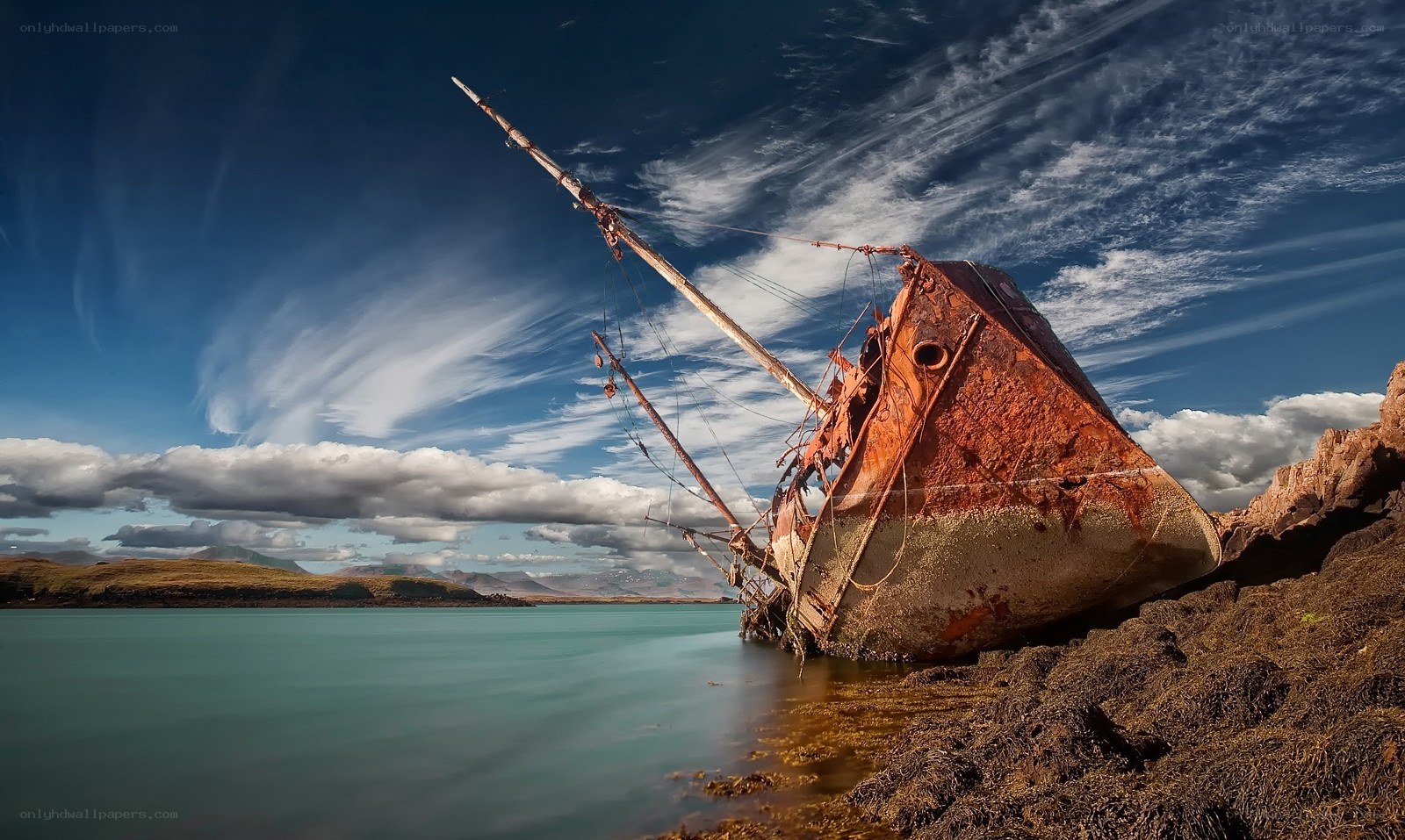 Rusty shipwreck on rocky shore