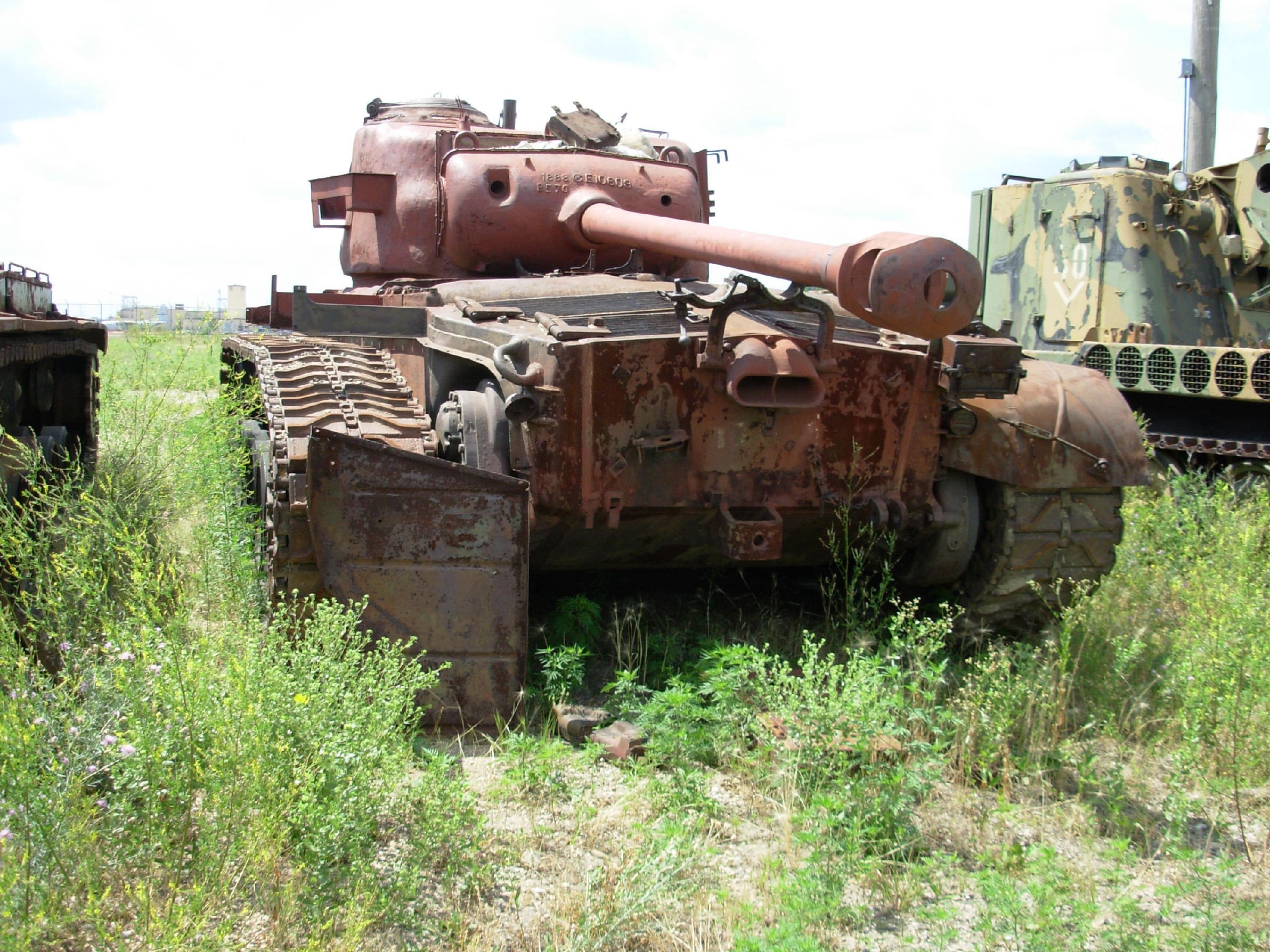 Rusty tank in overgrown field