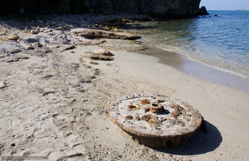 Rusty wheel on sandy beach