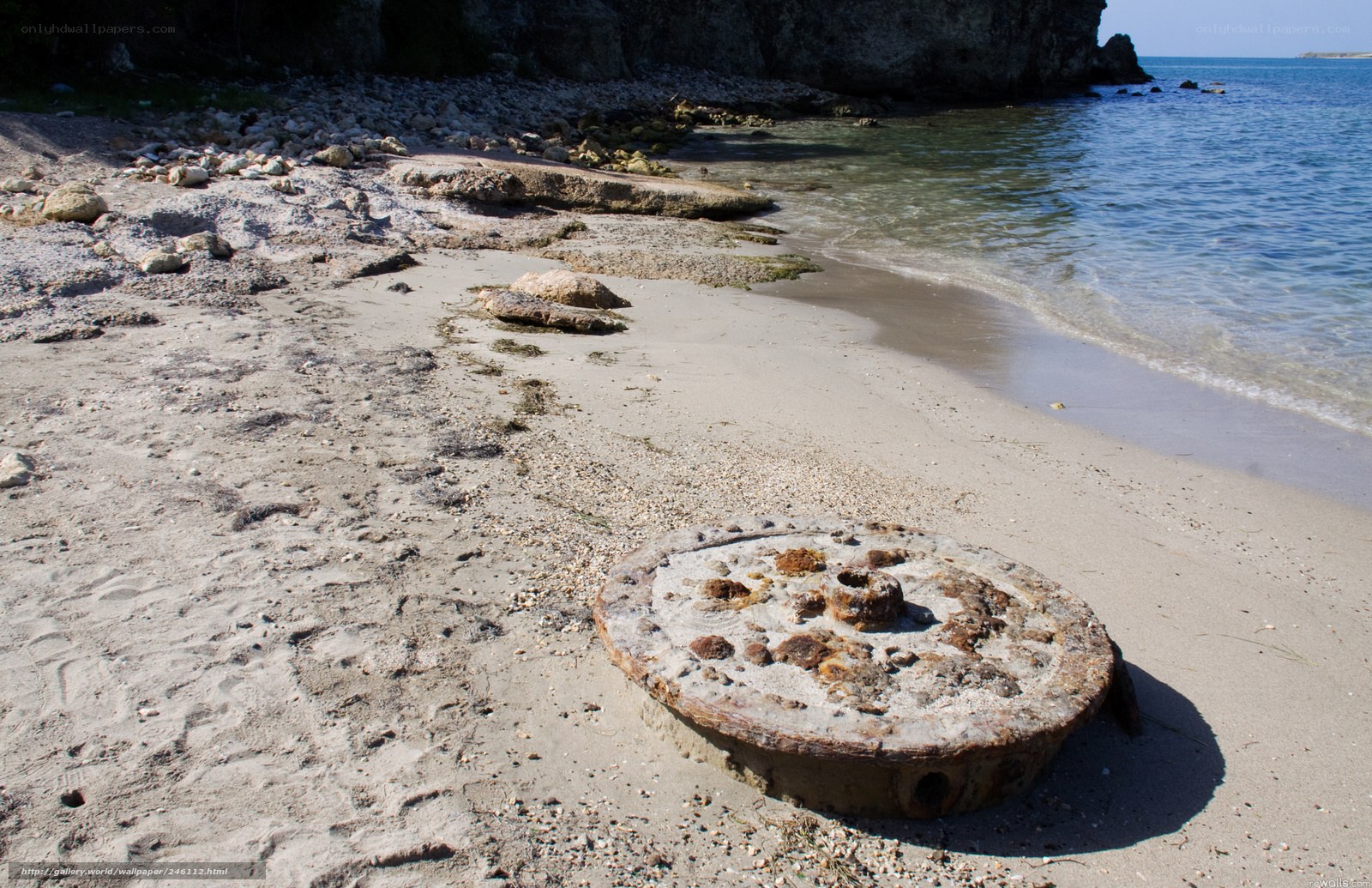Rusty wheel on sandy beach