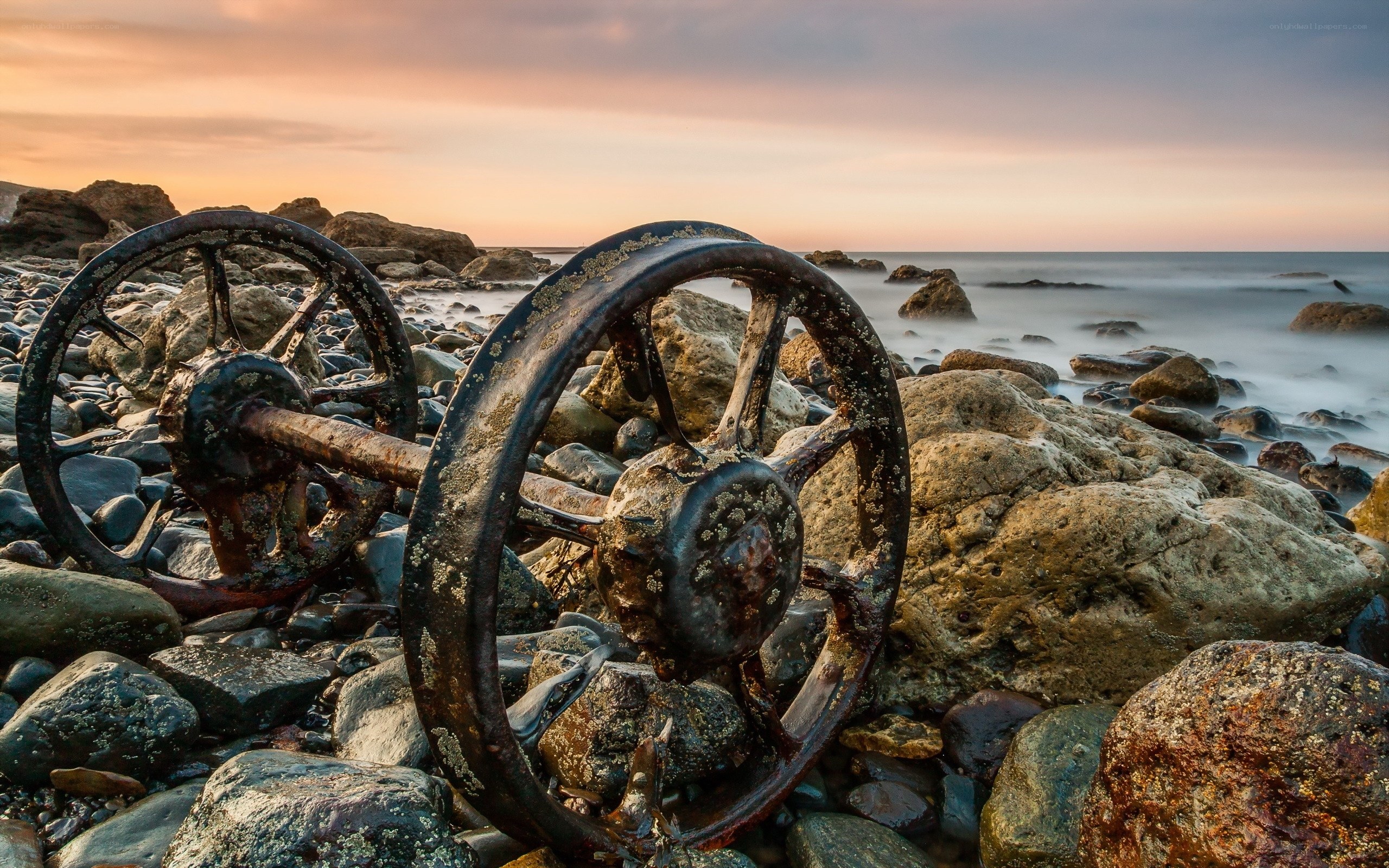 Rusty wheels on a rocky shore
