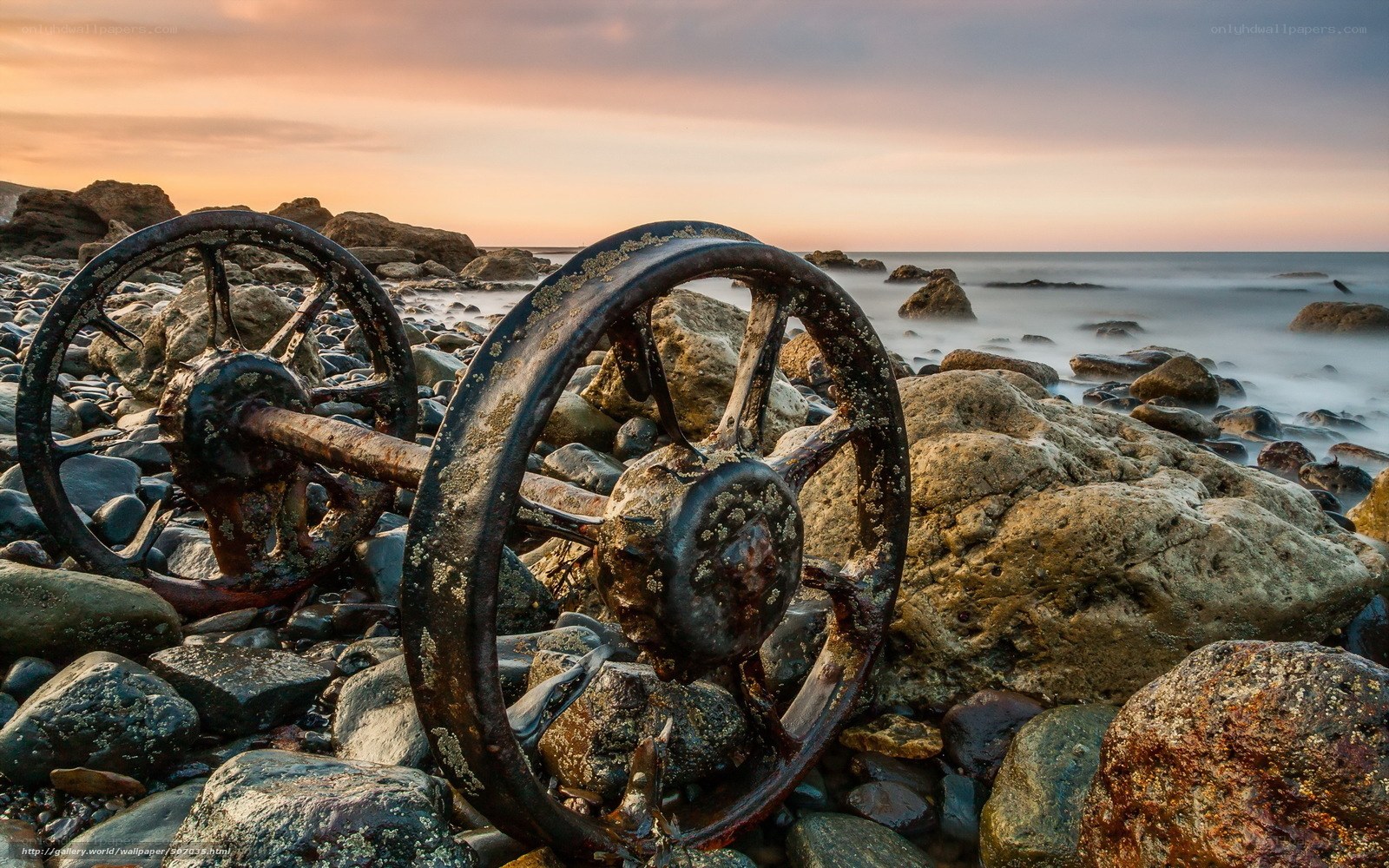 Rusty wheels on rocky shore
