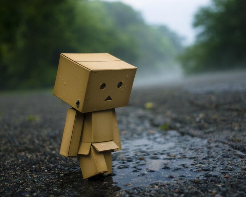 Sad cardboard robot in the rain